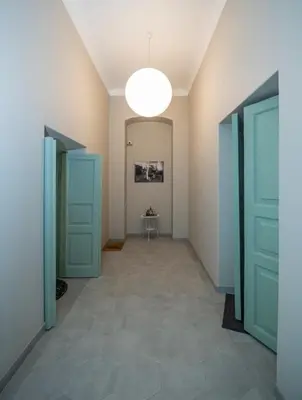 a hallway with blue doors and a table in a room at Telegrafas25-modern apartment in the center of Kaunas in Kaunas