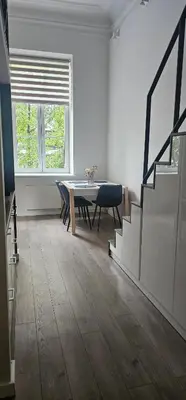 a living room with a table and chairs and a window at Telegrafas25-modern apartment in the center of Kaunas in Kaunas