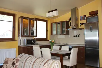 a kitchen with a table and chairs and a refrigerator at KaunaStayIn in Kaunas