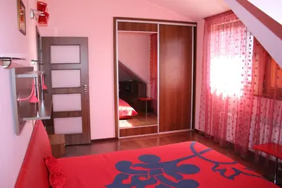 a living room with a red rug and a mirror at KaunaStayIn in Kaunas