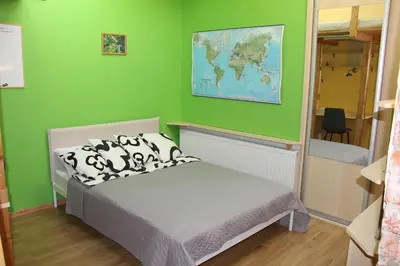 a bedroom with a bed with a green wall at KaunaStayIn in Kaunas
