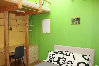a bedroom with green walls and a desk and a bunk bed at KaunaStayIn in Kaunas