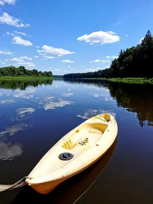 a yellow kayak sitting in the middle of a river at Nemo Keliones in Druskininkai