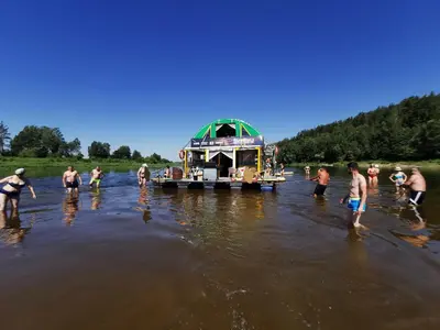 a group of people standing in the water with a boat at Nemo Keliones in Druskininkai