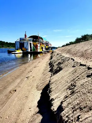 a boat is docked on a beach next to the water at Nemo Keliones in Druskininkai
