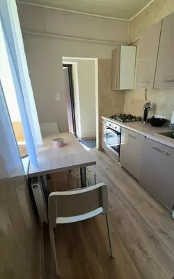 a kitchen with a table and a chair in it at Apartamentai Zibutės in Kaunas