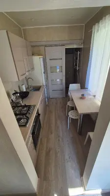 a small kitchen with a table and a stove at Apartamentai Zibutės in Kaunas