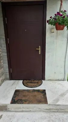 a brown door with a mat in front of it at Apartamentai Zibutės in Kaunas