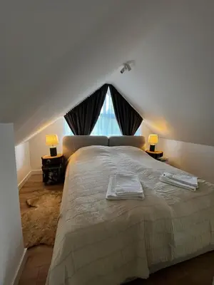 a bedroom with a large bed with a large window at Girios Horizontas - Mara in Trakai