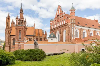 a large brick building with turrets and a church at Prestige Vilnius Old Town Apartment by Reside Baltic in Vilnius