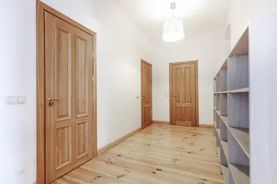an empty room with wooden doors and wooden floors at Prestige Vilnius Old Town Apartment by Reside Baltic in Vilnius