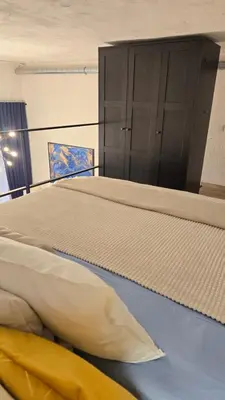 a large bed in a room with a large cabinet at BlueLoft Kaunas in Kaunas