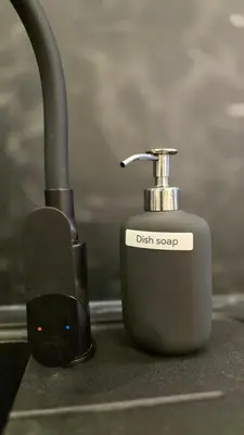 a dish soap container sitting on a kitchen counter at BlueLoft Kaunas in Kaunas