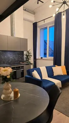 a living room with a blue couch and a table at BlueLoft Kaunas in Kaunas