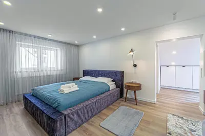 a bedroom with a blue bed in a room at Symphony Apartment with free parking in Kaunas
