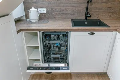 a dishwasher in a kitchen cabinet with a sink at Symphony Apartment with free parking in Kaunas