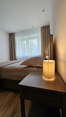 a bedroom with a bed and a table with a lamp at Jaukus butas Zarasu centre in Zarasai