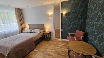 a bedroom with a bed and a table and a chair at Jaukus butas Zarasu centre in Zarasai