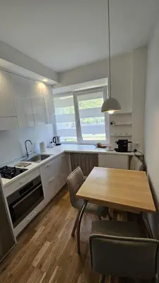 a kitchen with a wooden table and a table and chairs at Jaukus butas Zarasu centre in Zarasai