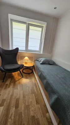 a bedroom with a bed and a chair and window at Jaukus butas Zarasu centre in Zarasai