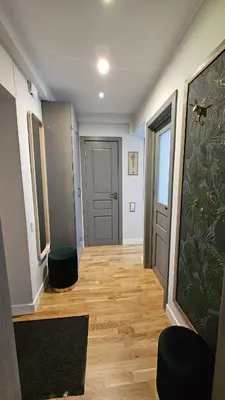 a hallway with wooden floors and a door with two stools at Jaukus butas Zarasu centre in Zarasai