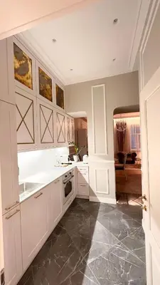 a kitchen with white cabinets and a tile floor at Old Town Residence Kaunas in Kaunas