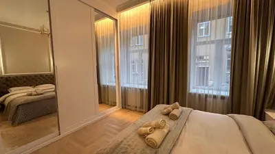 a bedroom with a mirror and a bed with towels at Old Town Residence Kaunas in Kaunas