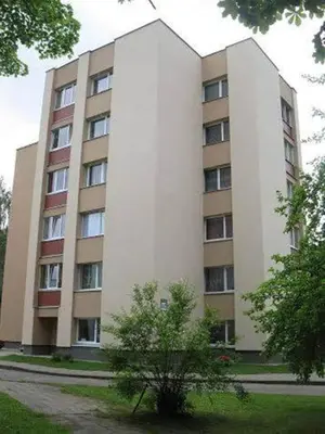 a large white building with a tree in front of it at Apartamentai Atostogos in Druskininkai