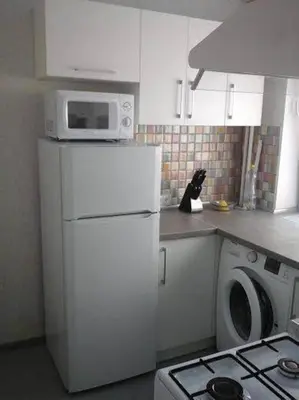 a kitchen with a microwave on top of a refrigerator at Apartamentai Atostogos in Druskininkai