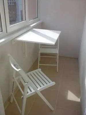 a white desk and a chair next to a window at Apartamentai Atostogos in Druskininkai