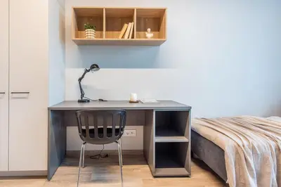 a desk in a bedroom with a bed and a chair at SHED Coliving studio in Vilnius