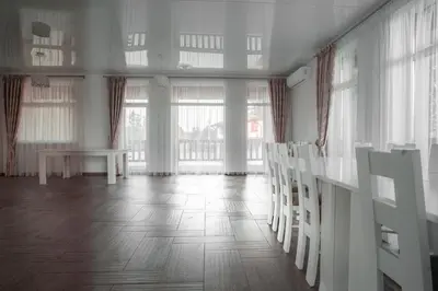 a room with a table and chairs and windows at Vėjo Malūnų sodyba - Didžioji vila in Paserninkai