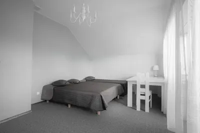 a bedroom with a bed and a desk and a table at Vėjo Malūnų sodyba - Didžioji vila in Paserninkai