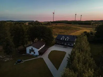 an aerial view of a house with windmills in the background at Vėjo Malūnų sodyba - Didžioji vila in Paserninkai