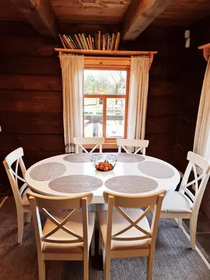 a dining room with a table and chairs and a window at Asvejos sodyba in Skirlėnai