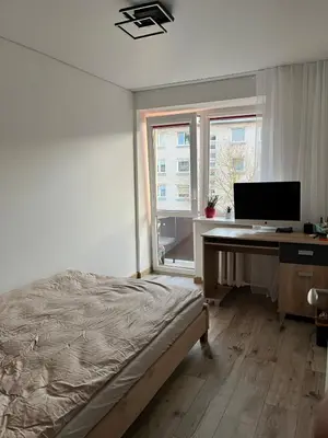 a bedroom with a desk with a computer on it at Very quiet and cozy place in Vilnius