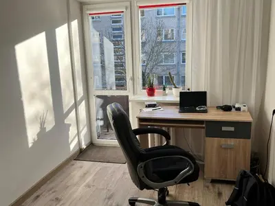 an office with a desk and a chair in front of a window at Very quiet and cozy place in Vilnius