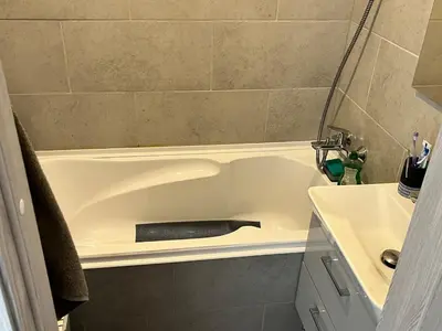 a bathroom with a bath tub with a black object in it at Very quiet and cozy place in Vilnius