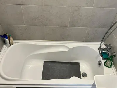 a white bath tub with a black mat in it at Very quiet and cozy place in Vilnius