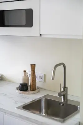 a kitchen counter with a sink and a microwave at GOOD LOCATION studio near the old town - station - airport - self check in in Vilnius