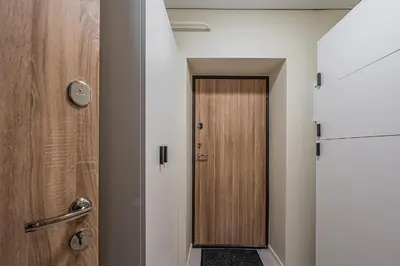 a hallway with a wooden door in a room at GOOD LOCATION studio near the old town - station - airport - self check in in Vilnius