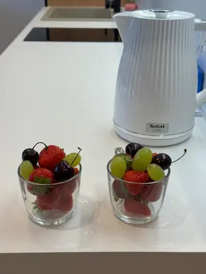 two bowls of fruit on a counter next to a blender at V4 Europa New Apartment in Vilnius