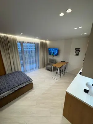 a bedroom with a bed and a desk in a room at V4 Europa New Apartment in Vilnius