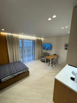 a bedroom with a bed and a desk in a room at V4 Europa New Apartment in Vilnius