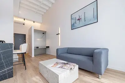 a living room with a blue couch and a table at RADIO CITY Loft 345 by Domvia in Kaunas