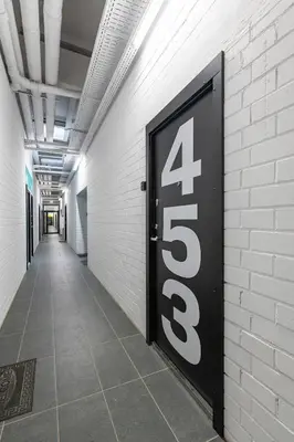 a door with the on a white brick wall at RADIO CITY Loft 435 by Domvia in Kaunas