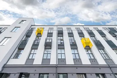 a tall white building with yellow boxes on it at RADIO CITY Loft 435 by Domvia in Kaunas