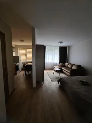 a room with a bed and a living room with a couch at Egidijaus apartamentai Panevėžyje in Panevėžys