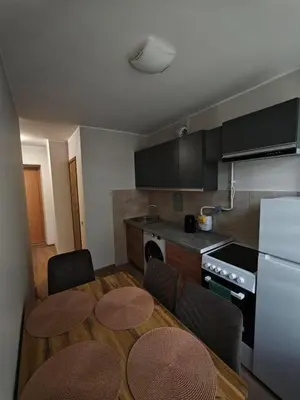 a kitchen with a table and two chairs and a kitchen with a stove at Egidijaus apartamentai Panevėžyje in Panevėžys