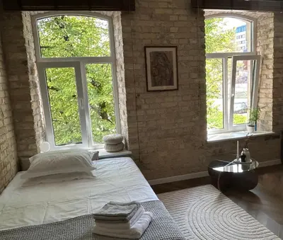 a bedroom with two windows and a bed with towels at Studio in Oldtown in Vilnius